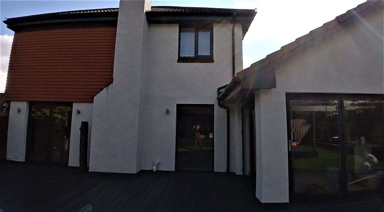 roughcast repair on modern two-storey house front façade