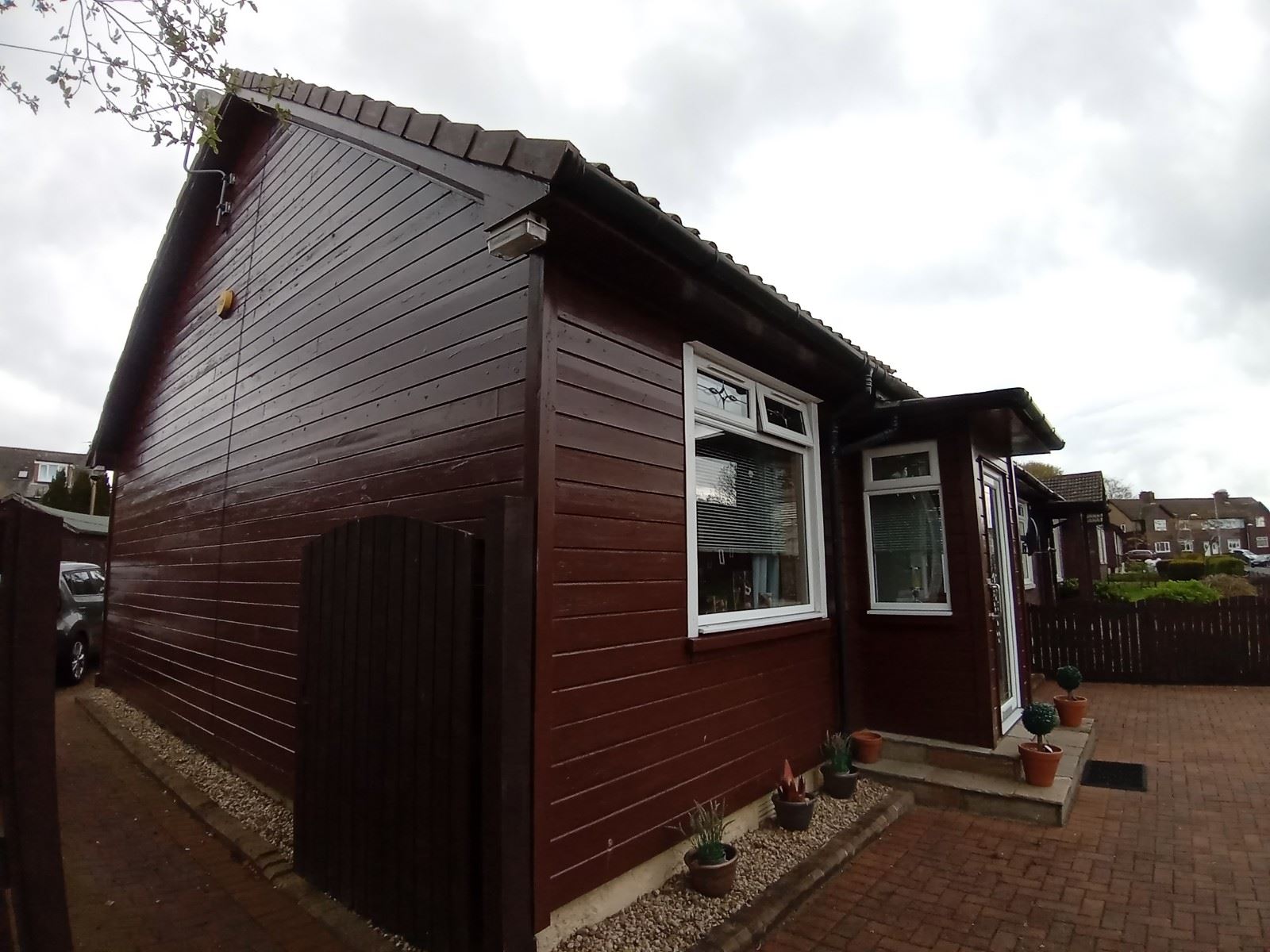 roughcaster Edinburgh working on corner elevation of house with timber cladding