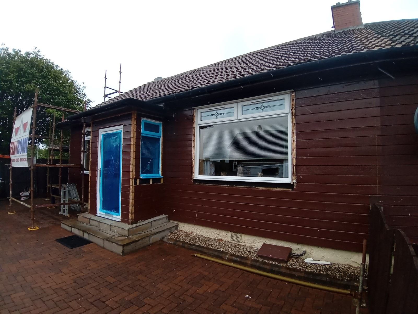 roughcast render repair on property façade during insulation stage