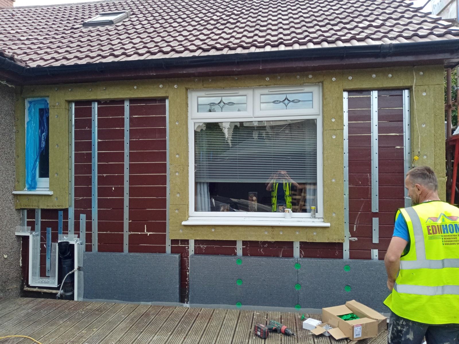 roughcast render repair with red and grey insulation boards installed