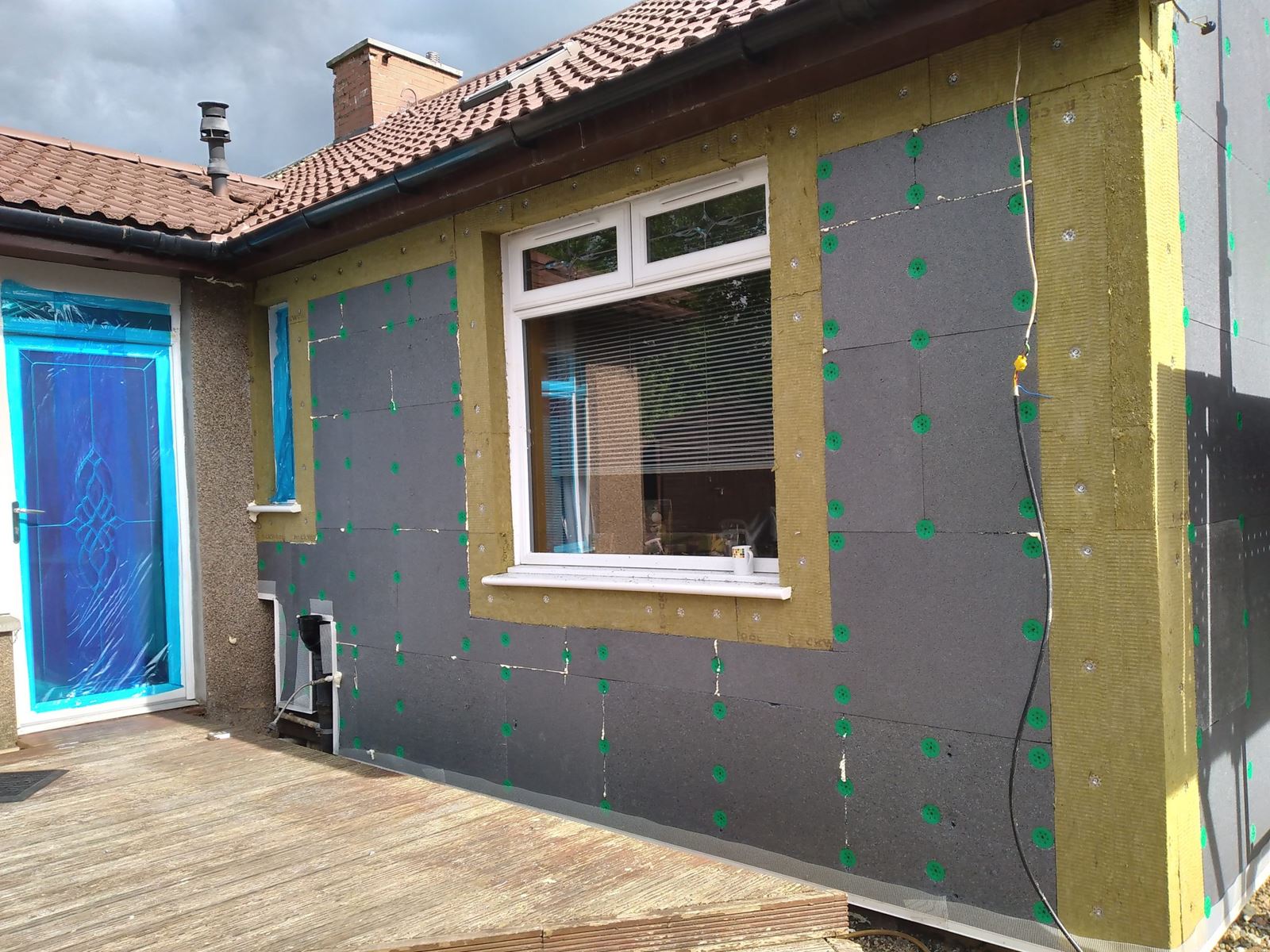 roughcaster Edinburgh working on exterior wall insulation near window