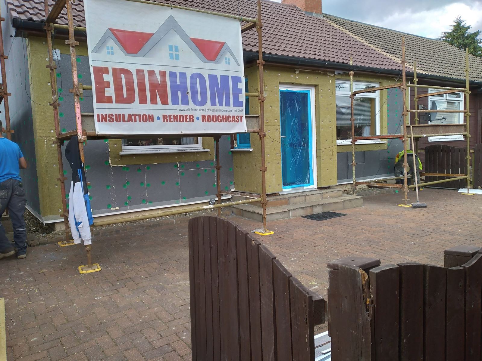 roughcast render Edinburgh renovation project with scaffold and banner