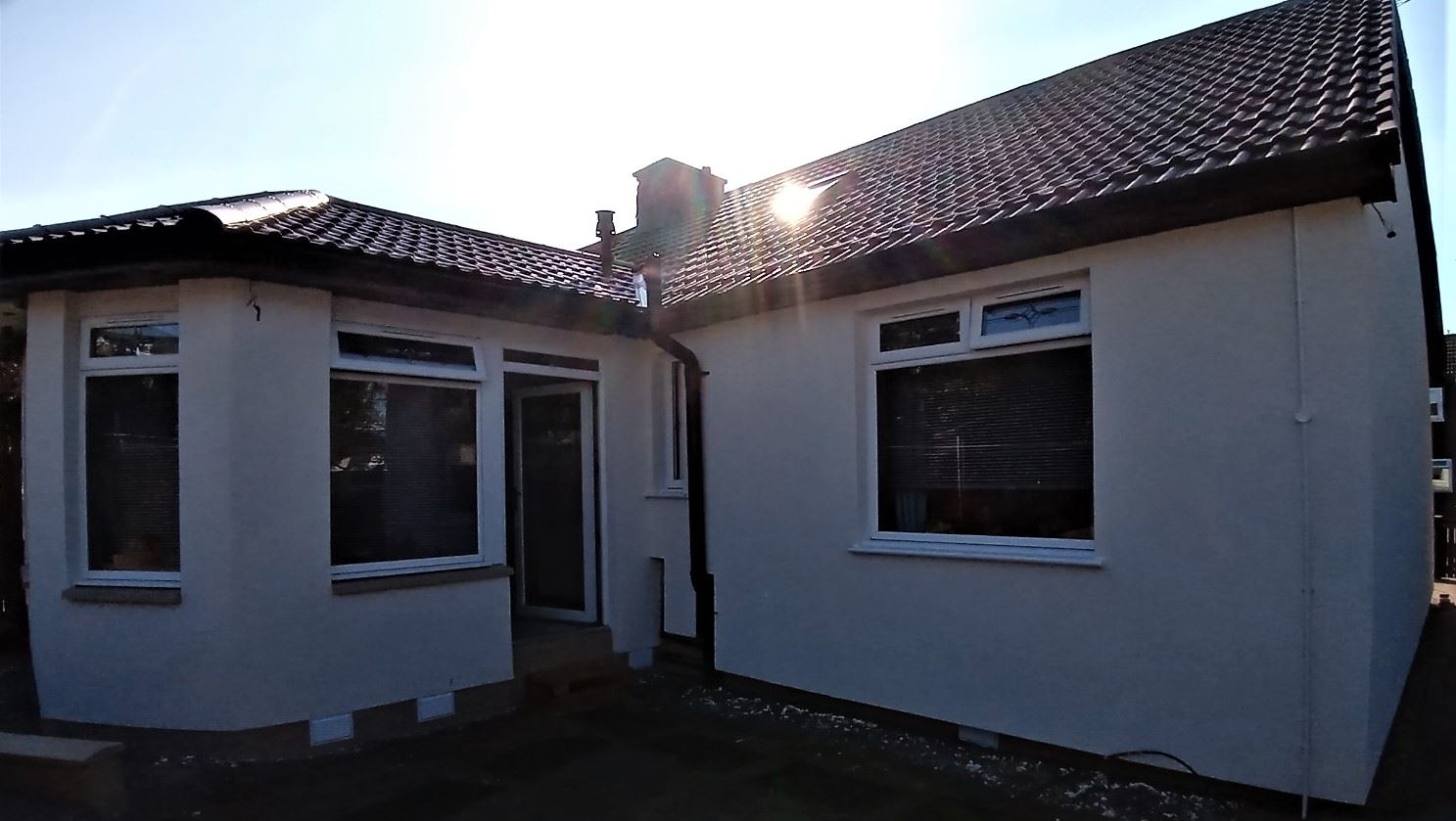 roughcast render repair on rear elevation of single-storey home