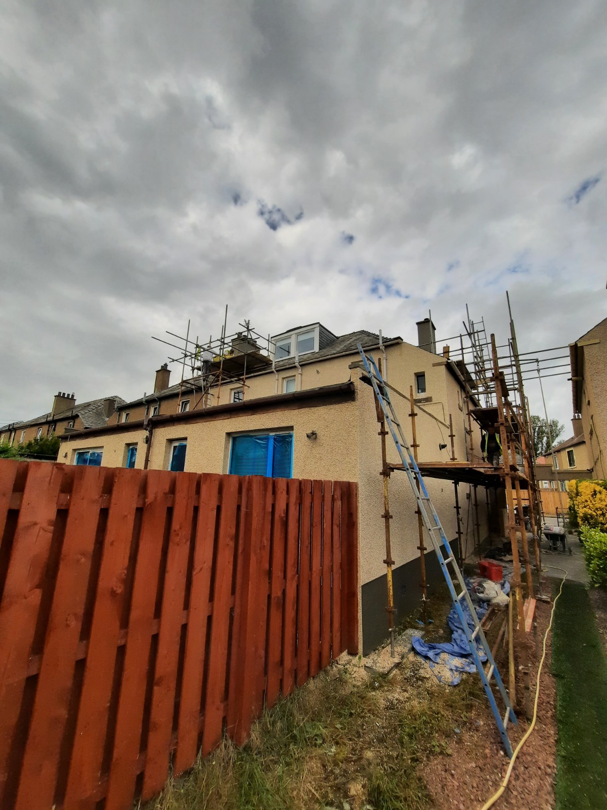 roughcasting Edinburgh on house with full scaffolding beside red fence