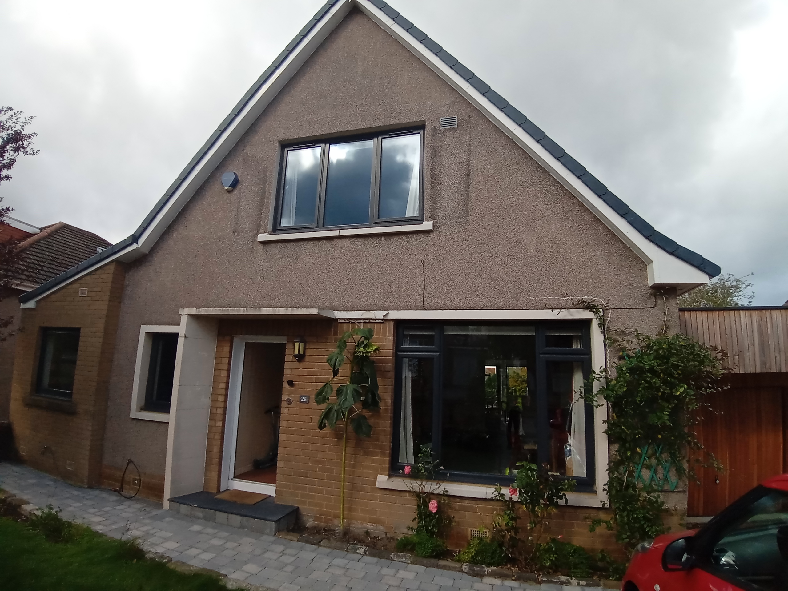 roughcast render Edinburgh on front façade of house with gable roof and porch
