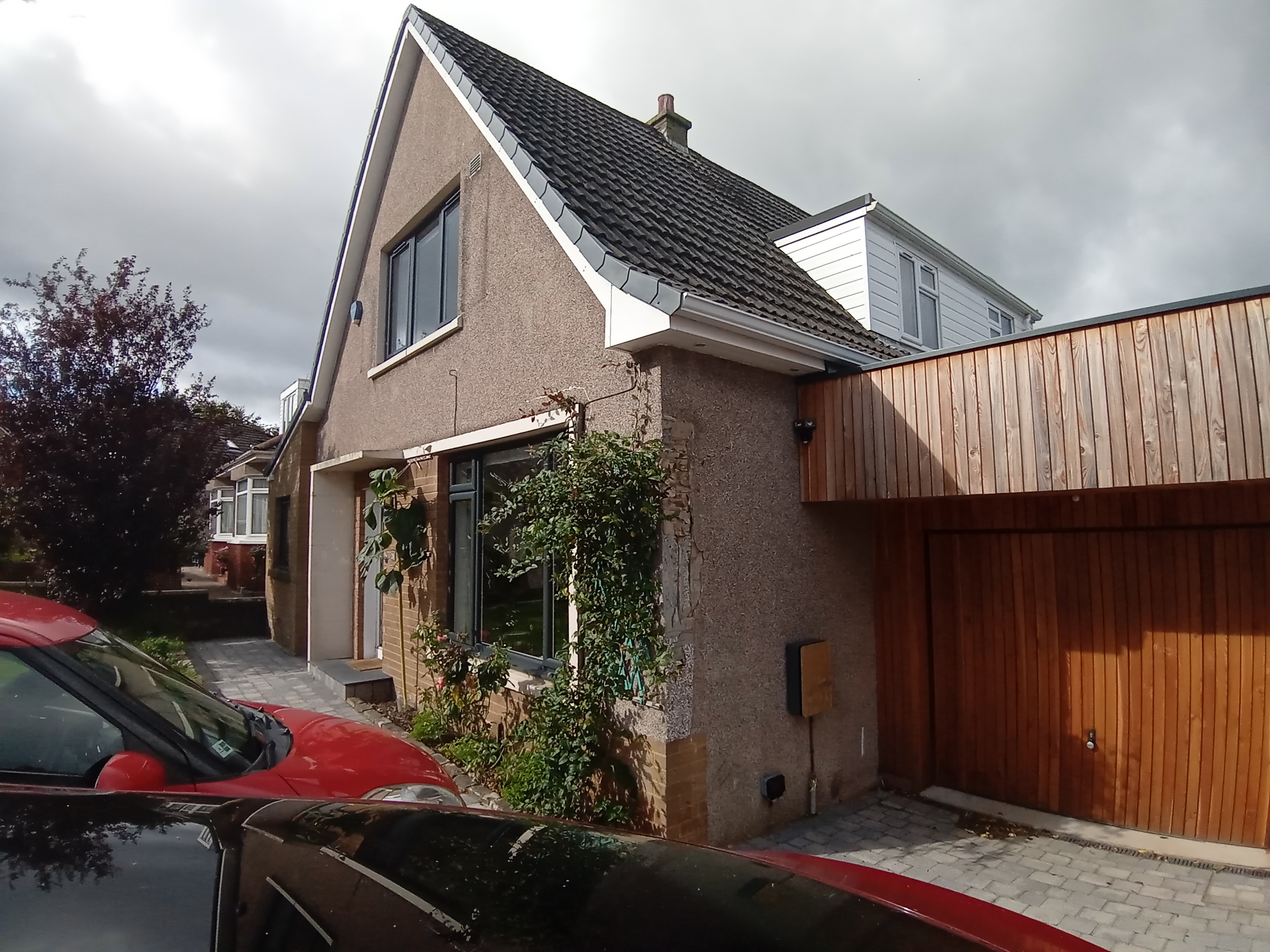 roughcast render repair on front façade of house with pitched roof