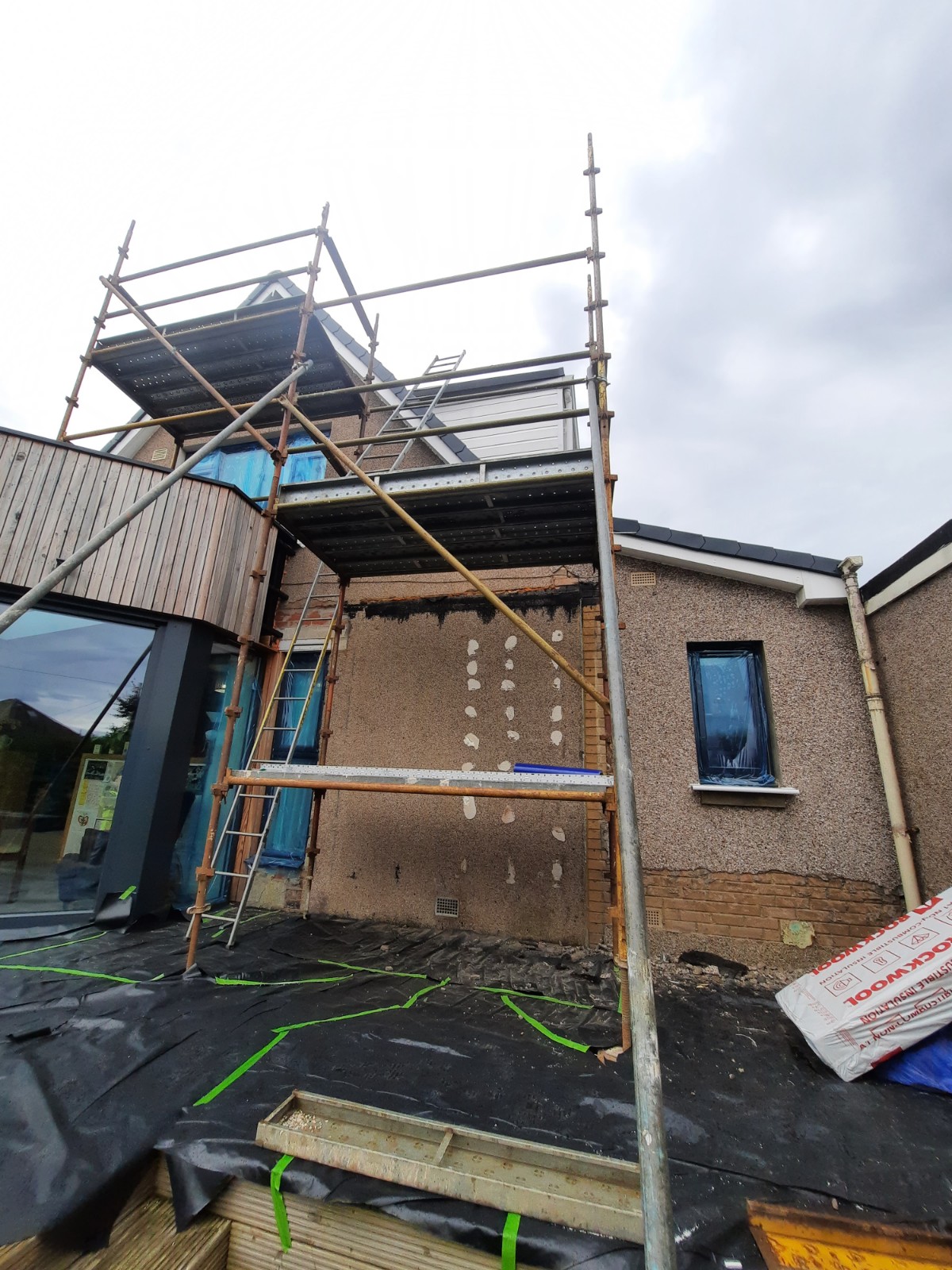 roughcast render repair on large wall with scaffolding setup
