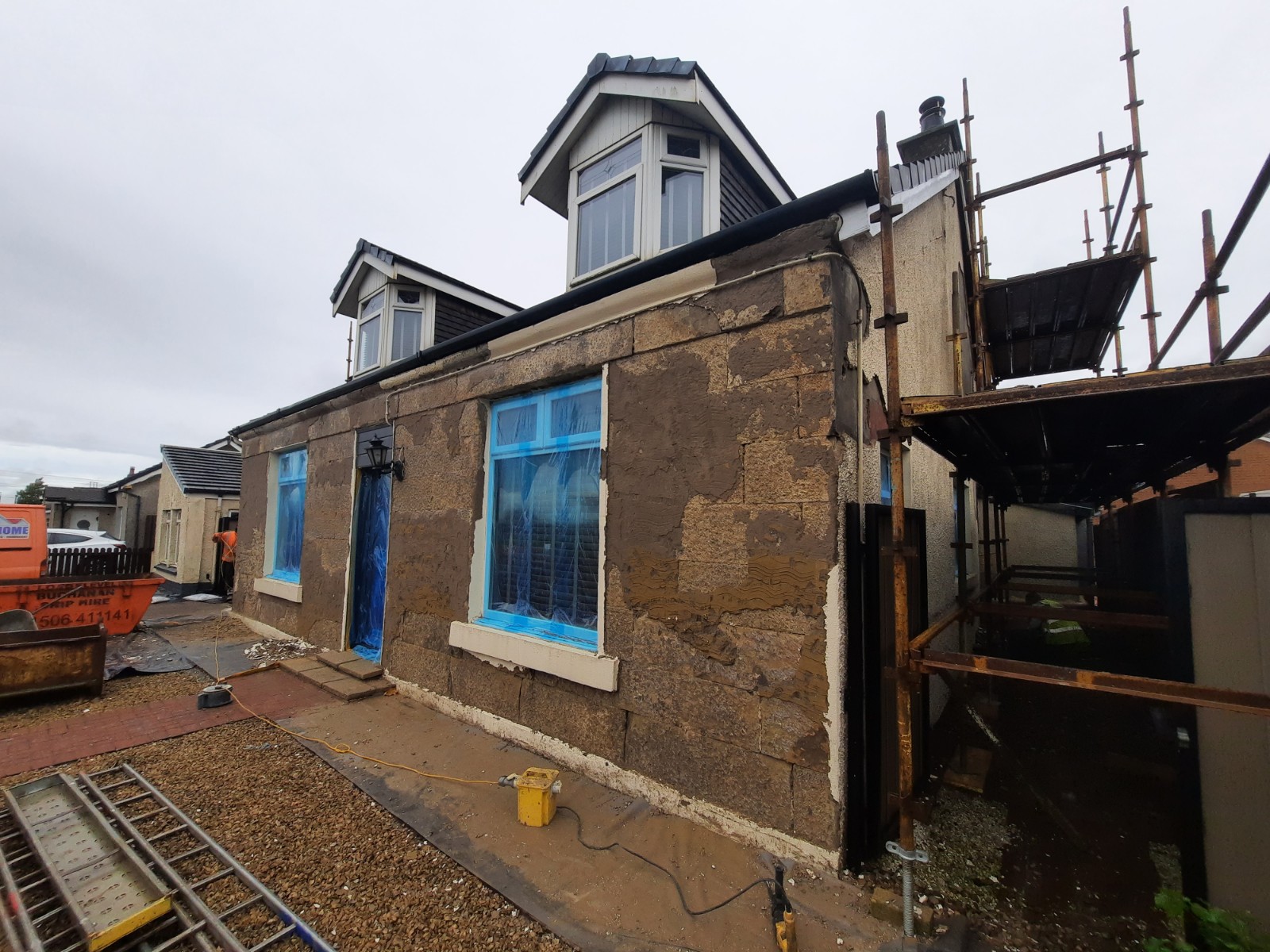 roughcast render Edinburgh wall stripped exposing brown substrate