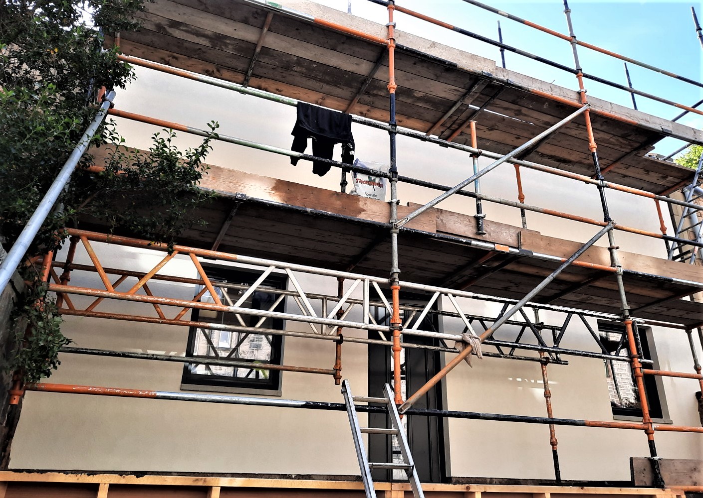 Rendering Edinburgh on upper façade with scaffolding and workers