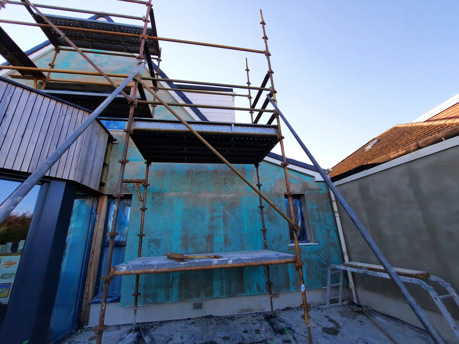 roughcast repair on wall with blue window protection
