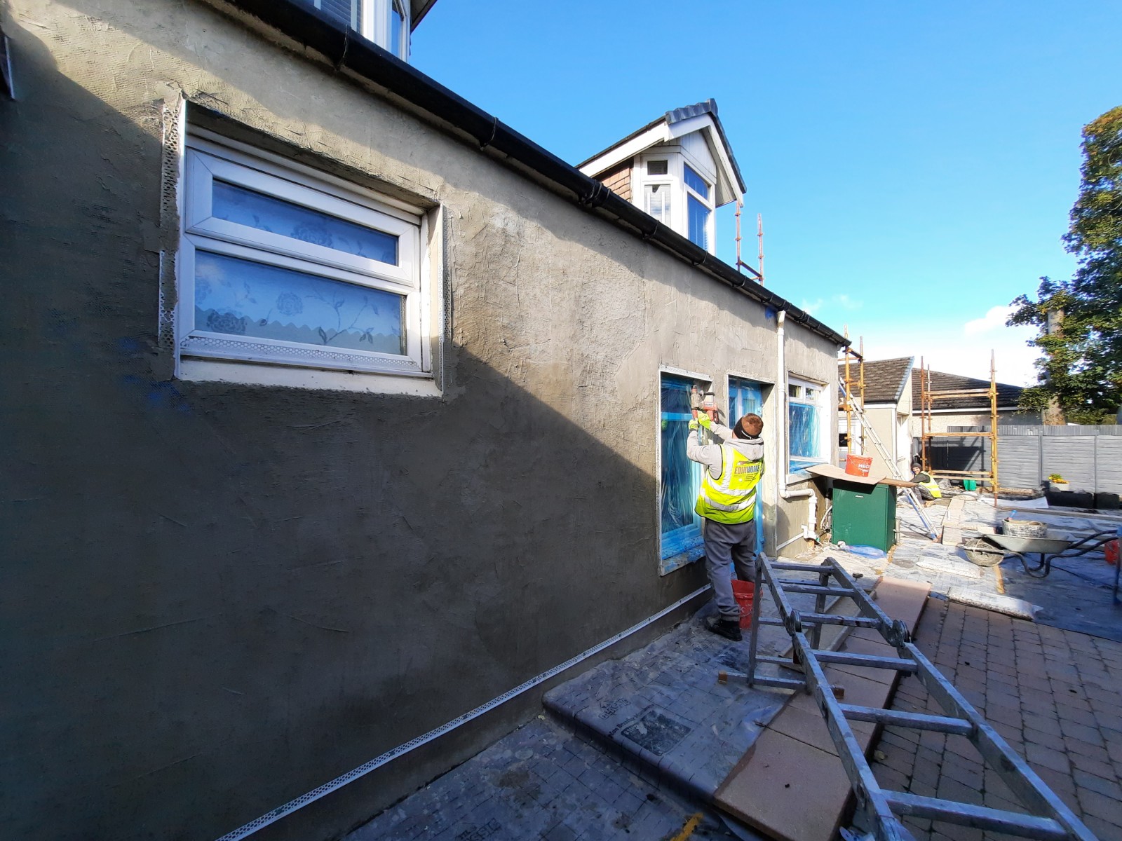 workers applying coat during house rendering Edinburgh
