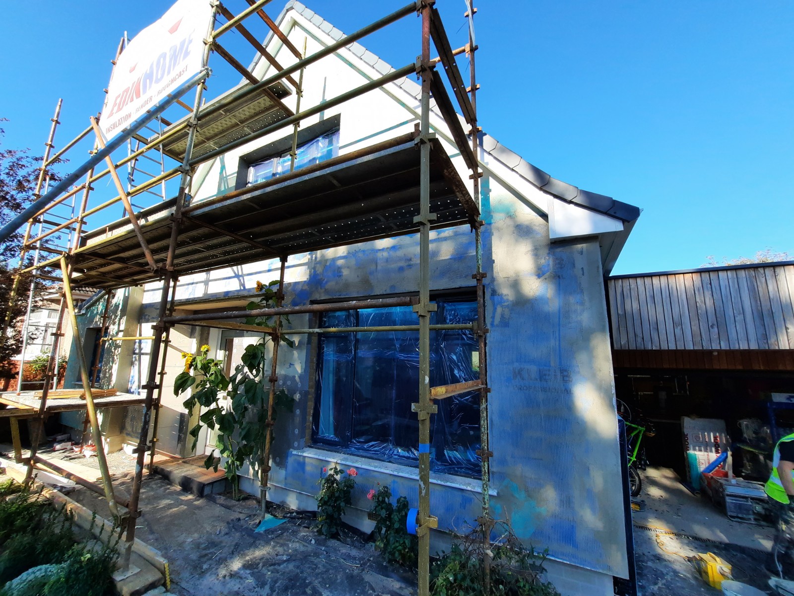 roughcast render repair on side façade with visible scaffolding