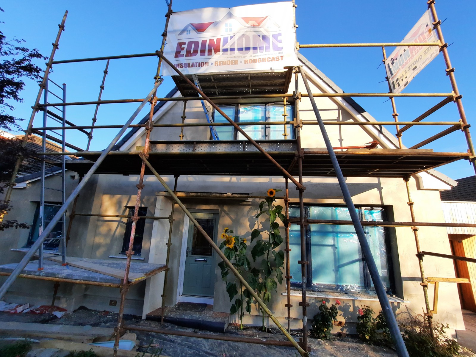 roughcasting Edinburgh on scaffolded front with banner