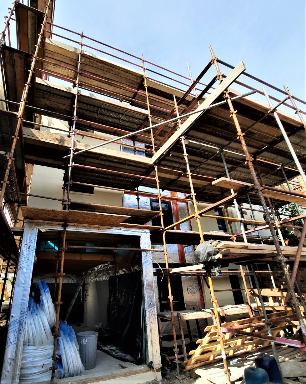 roughcast render repair on corner elevation with wooden beams