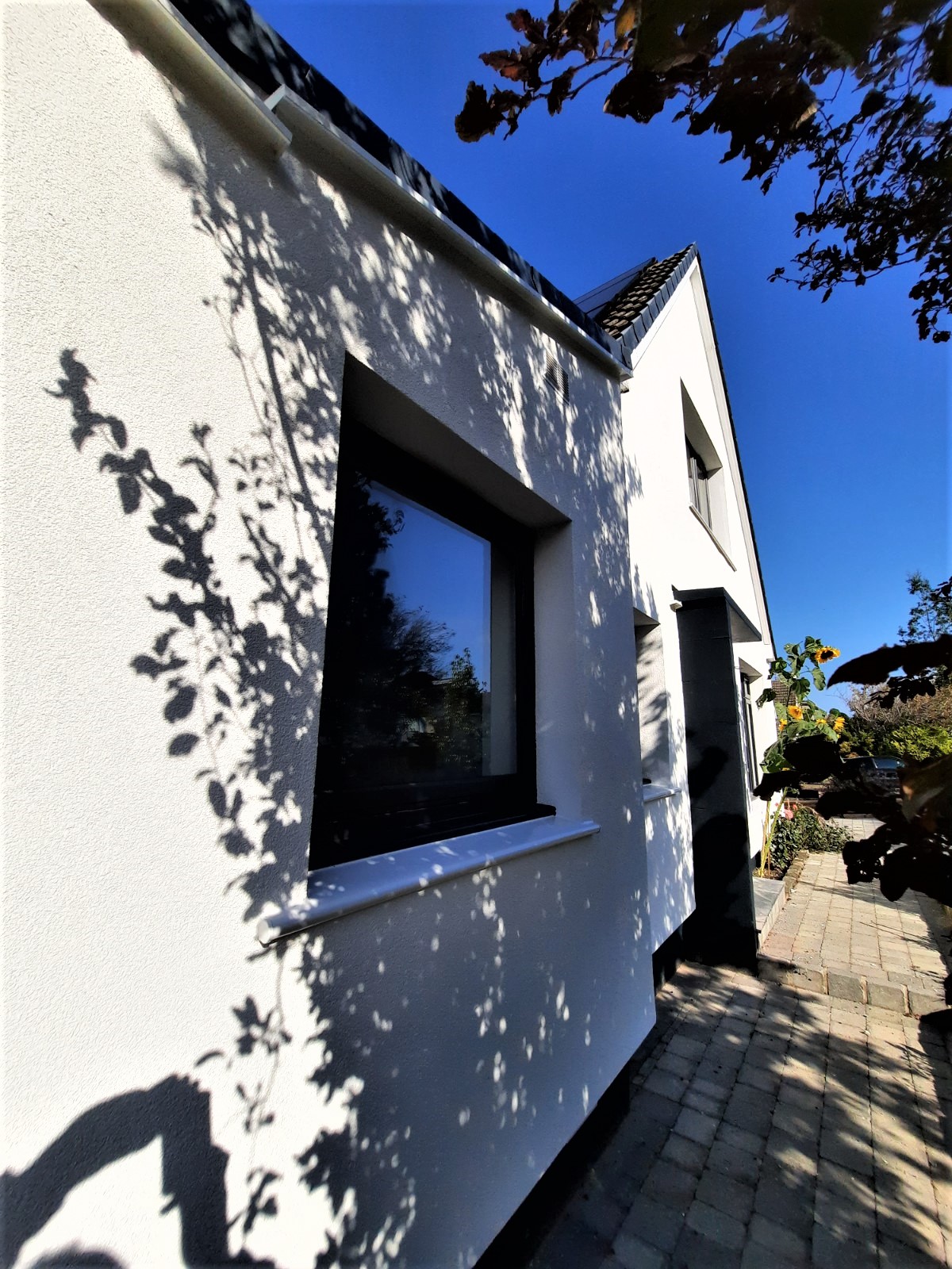 roughcast repair around corner of white modern house