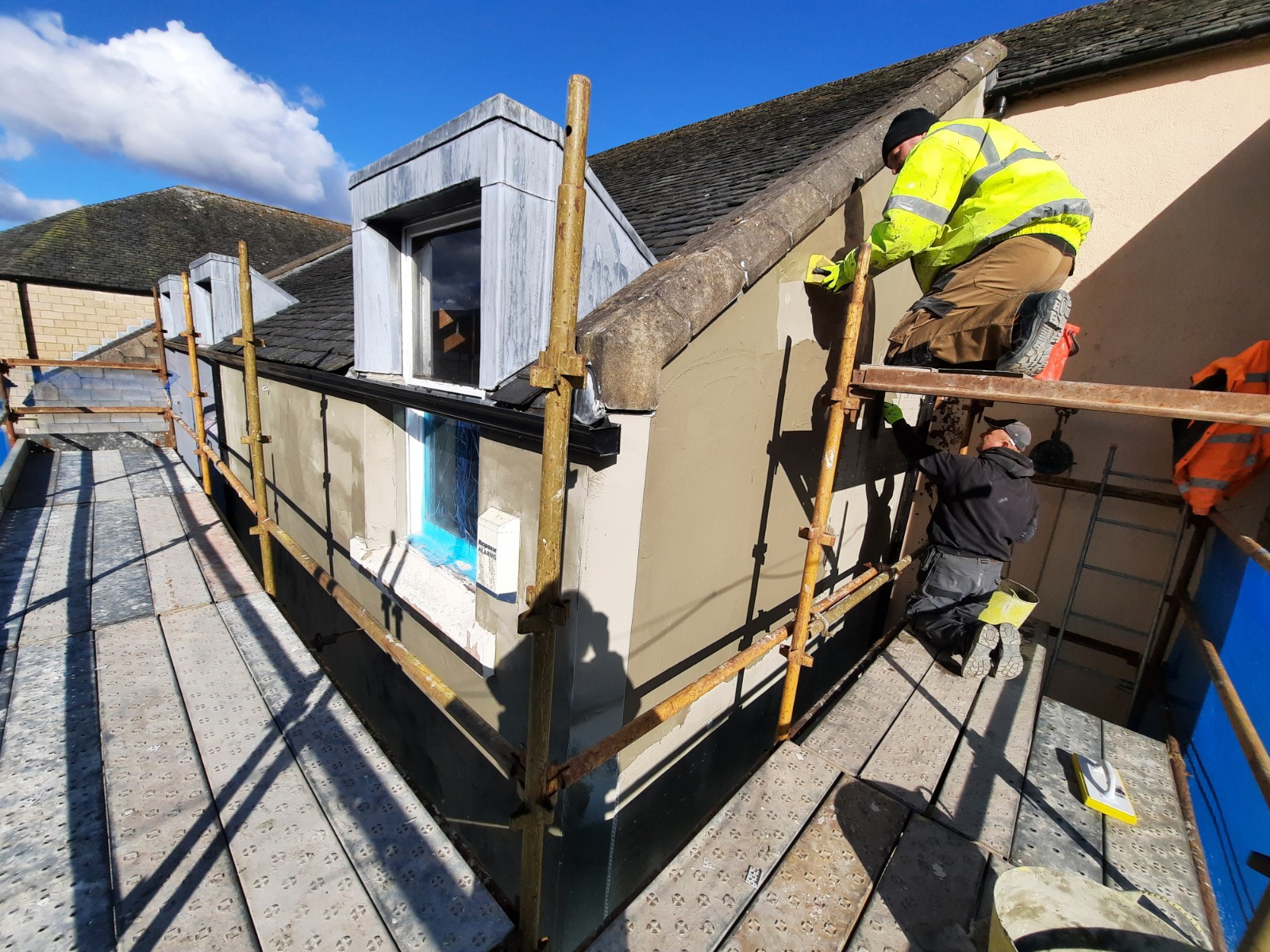 rooftop worker applying roughcast render Edinburgh