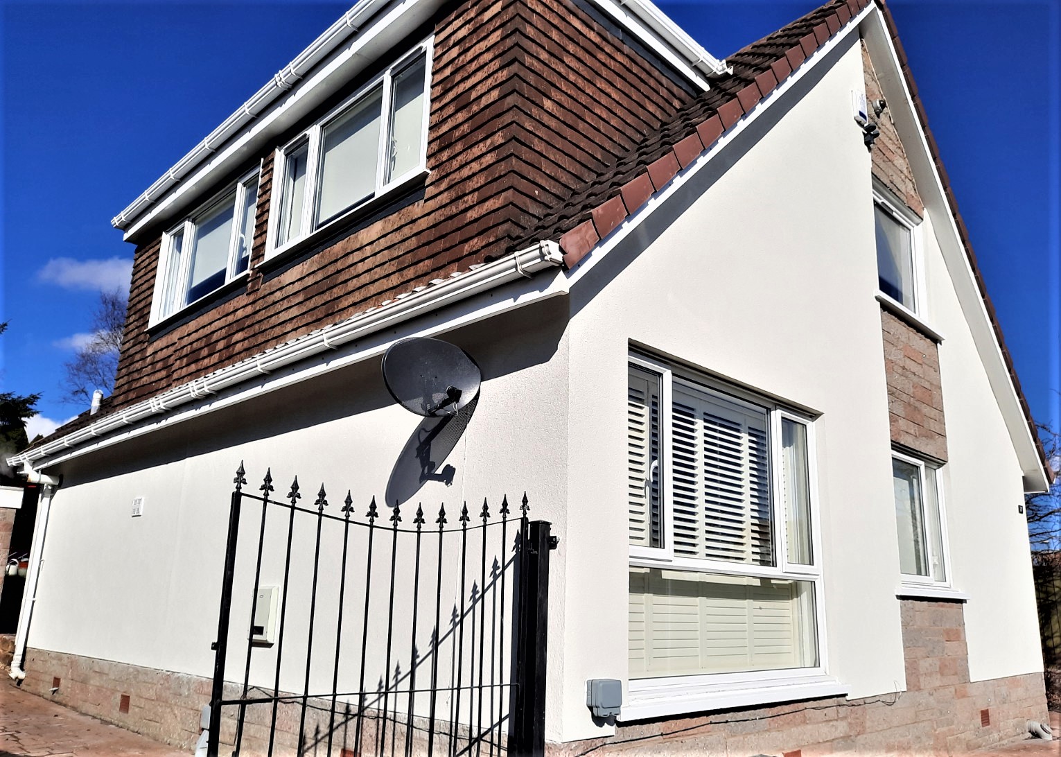 white facade with satellite dish and roughcast render Edinburgh