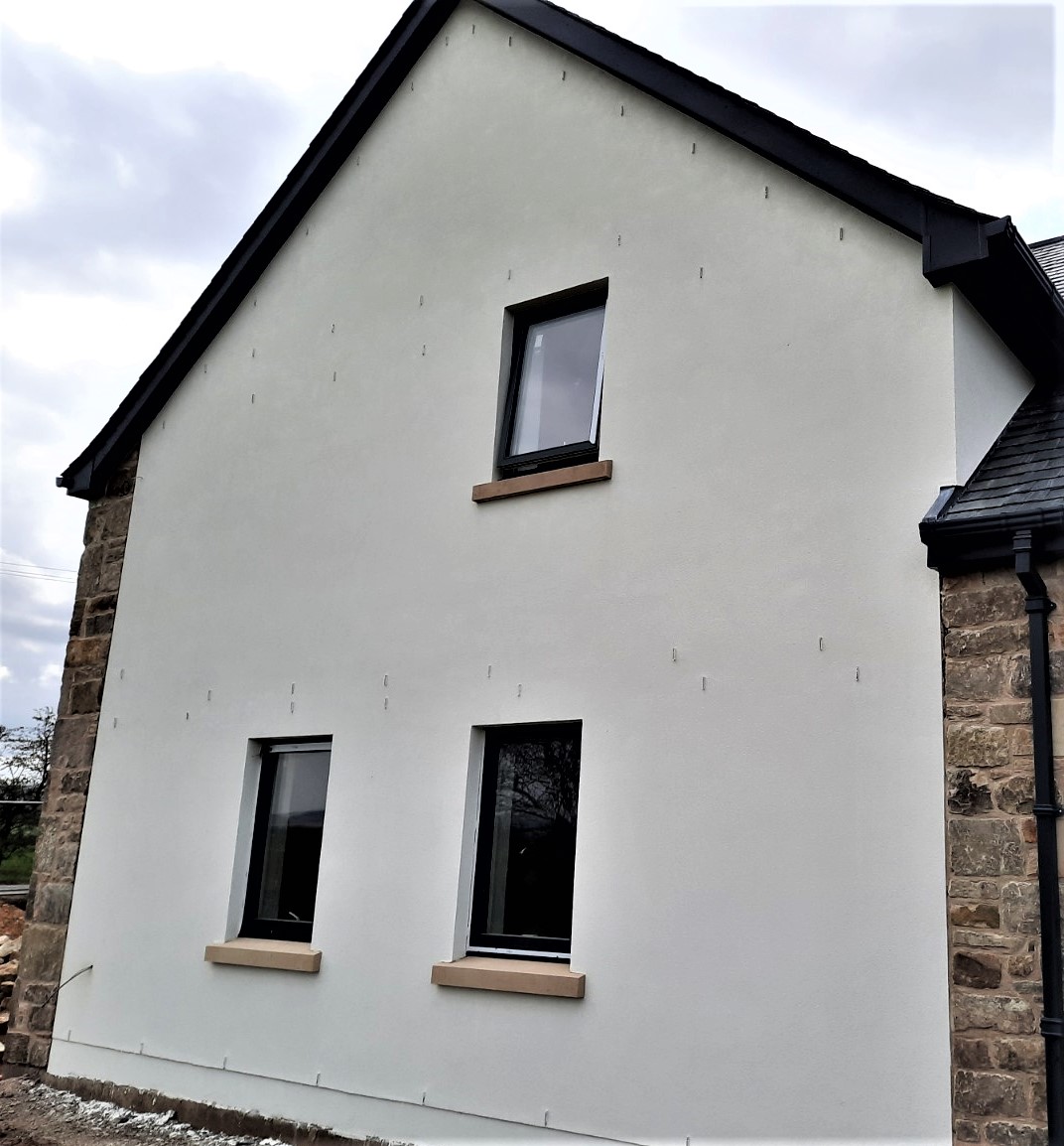 two windows on white roughcast render Edinburgh wall