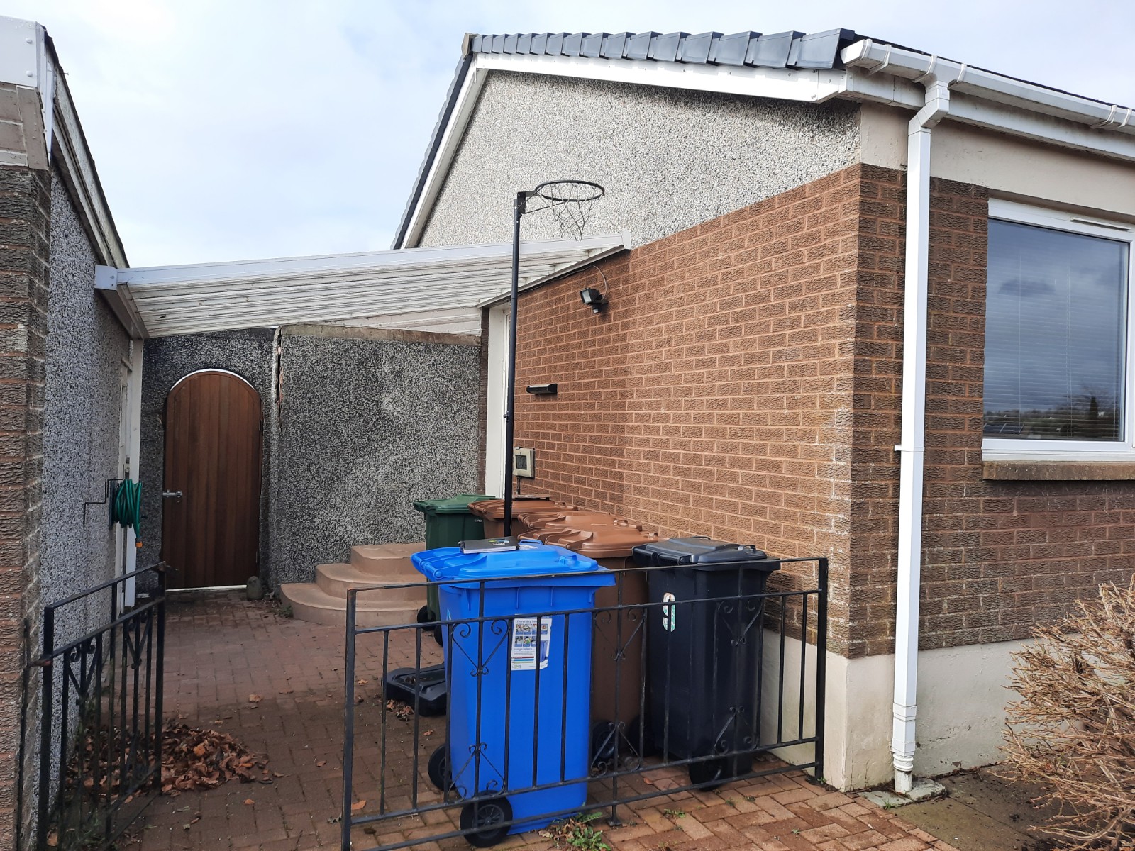 roughcasting Edinburgh on mixed brick and rendered side wall near bins
