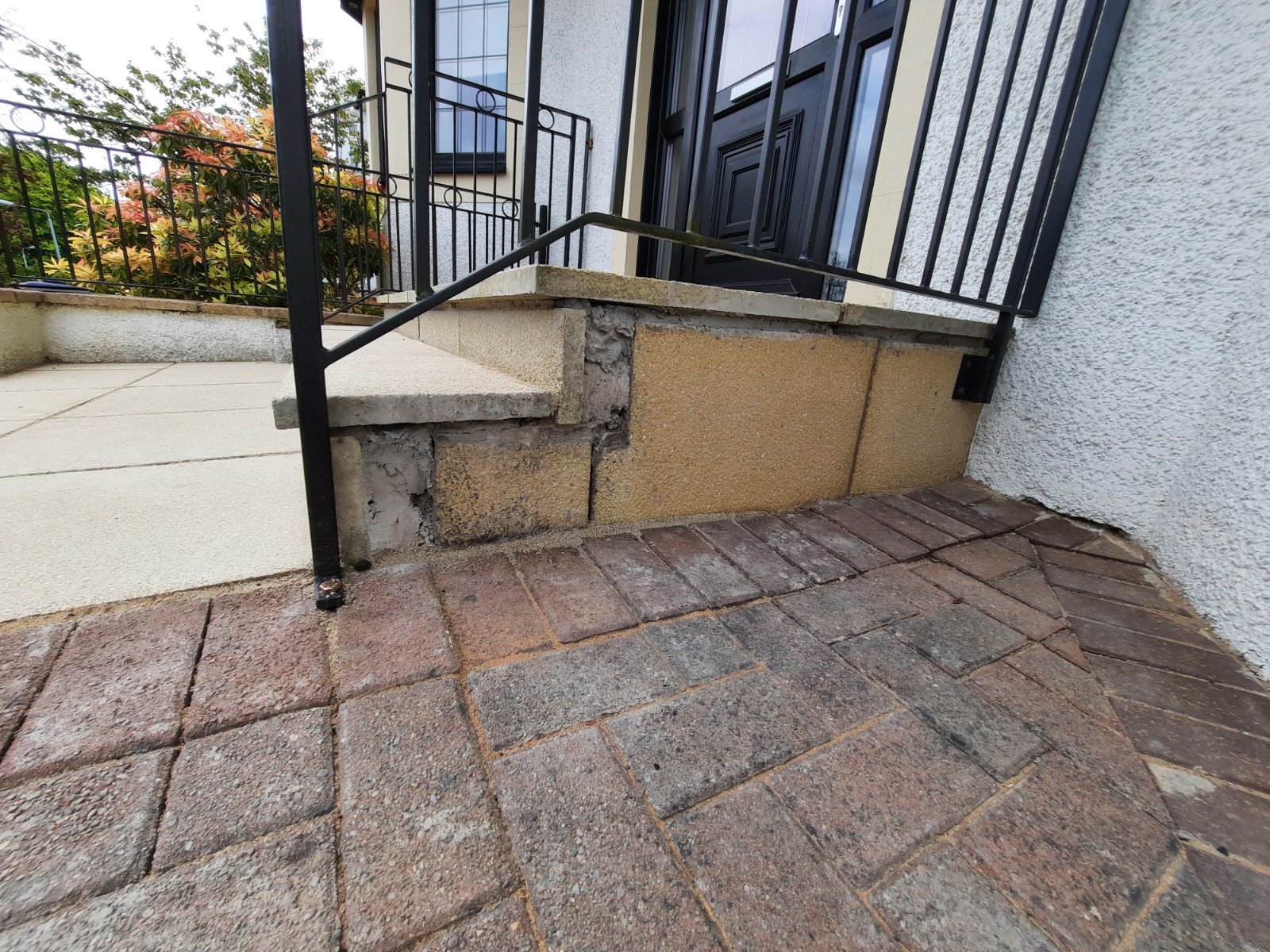 roughcasting Edinburgh on damaged wall section beside garden steps