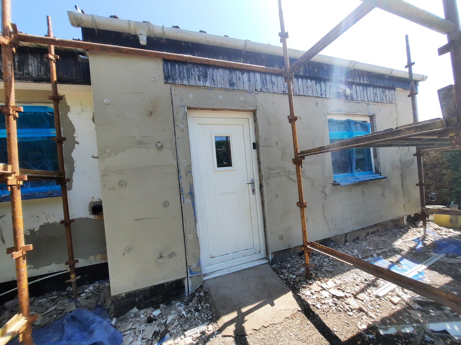 roughcast repair on single-storey wall with door and flat roof