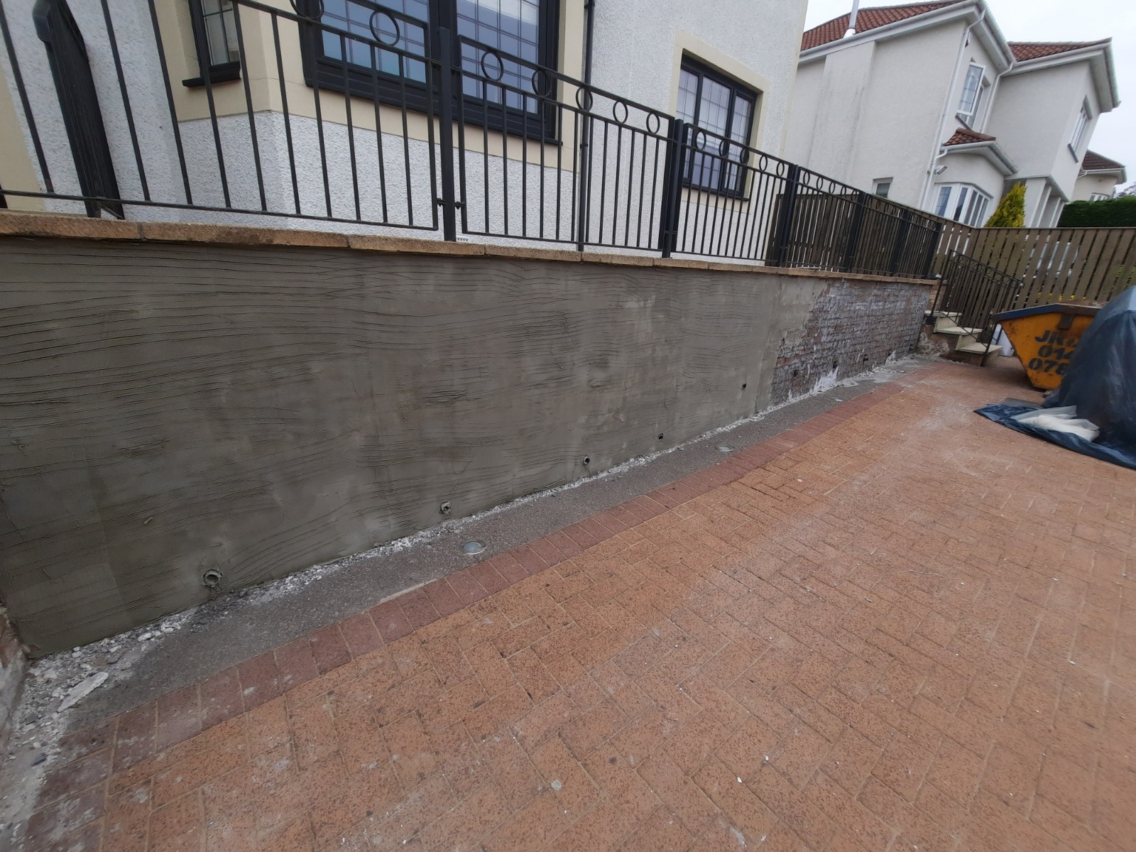 house rendering Edinburgh on low wall beside driveway entrance