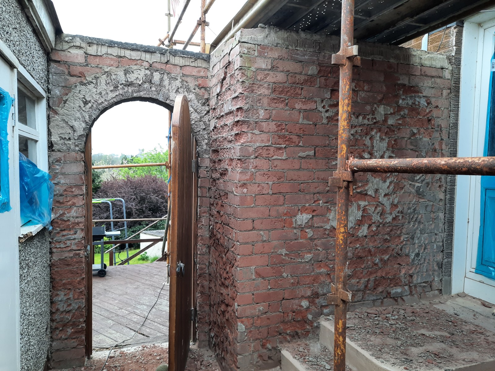 roughcast render repair on arched brick entrance