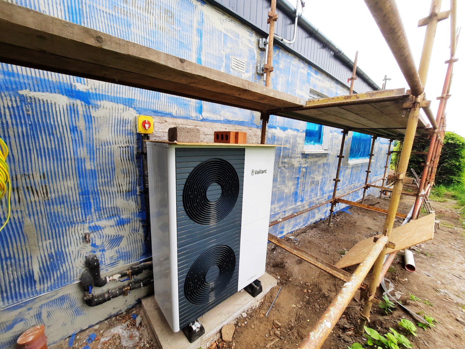 roughcasting Edinburgh applied over insulation panels beside heat pump unit