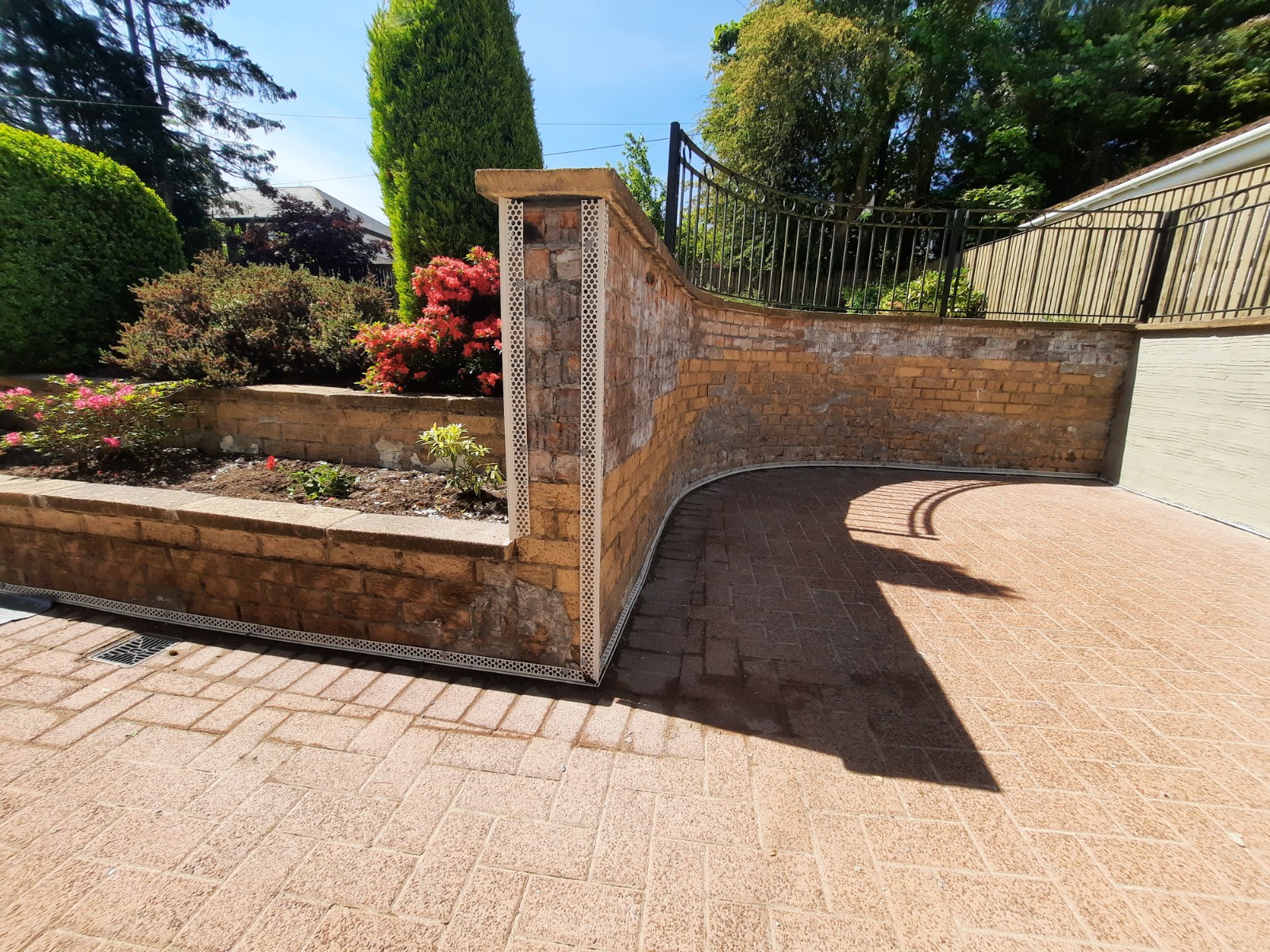 roughcast repair on planter wall next to flower bed