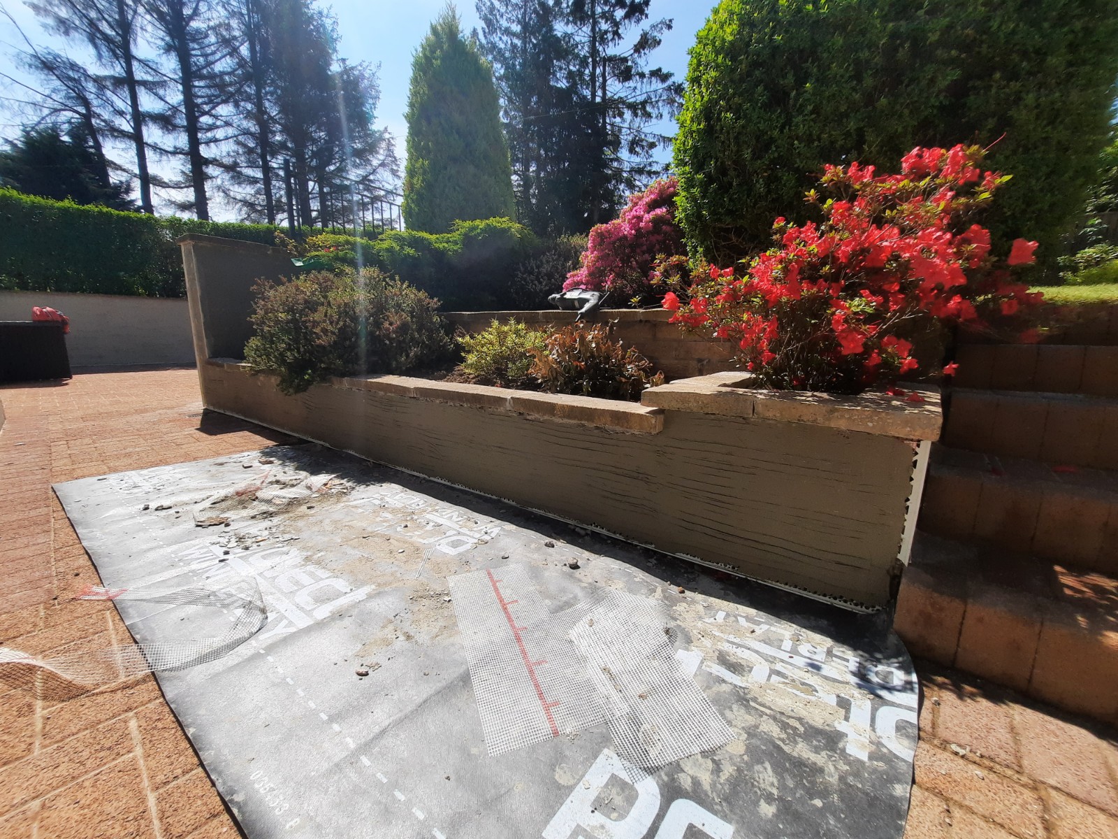 roughcast render repair preparation on curved paved area wall