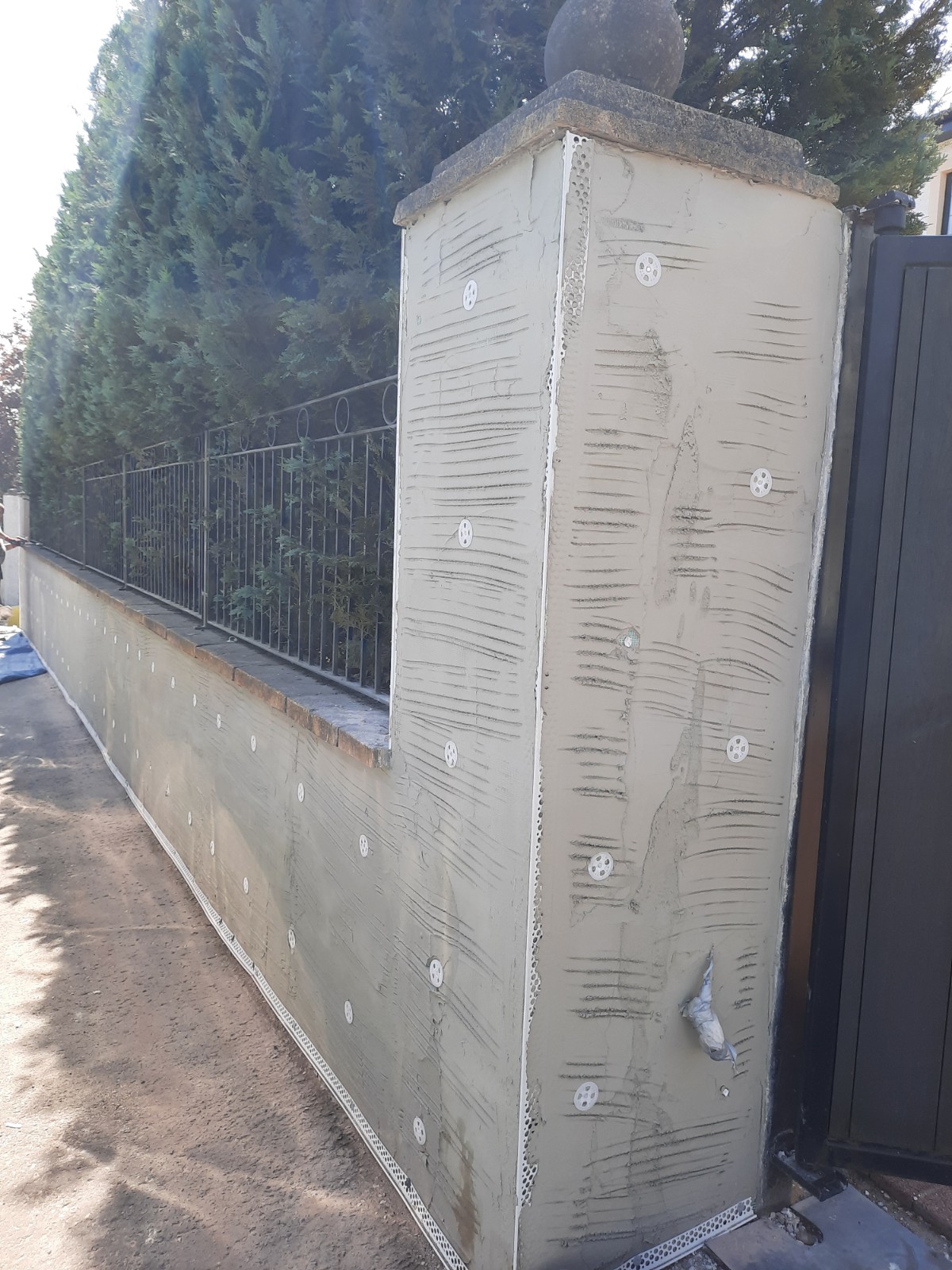 roughcast render repair on tall side wall with scaffolding