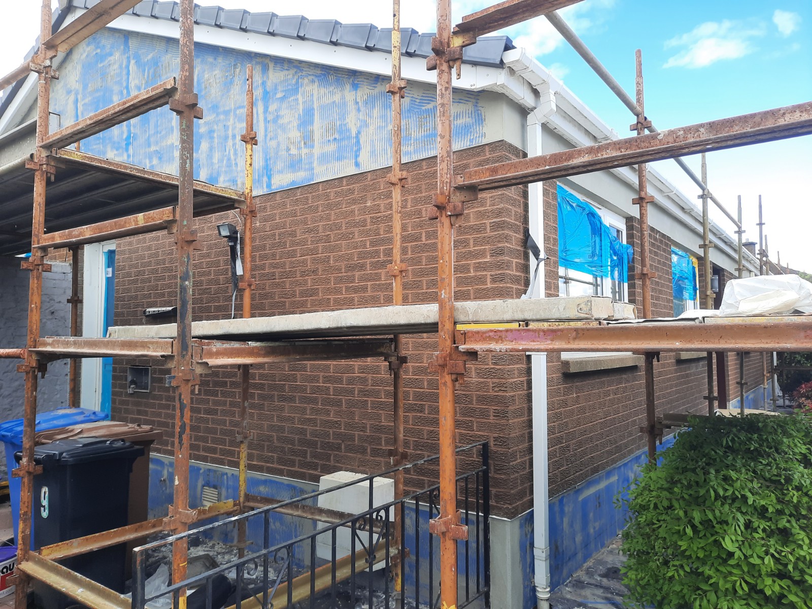 roughcast render repair on rear conservatory wall with scaffolding