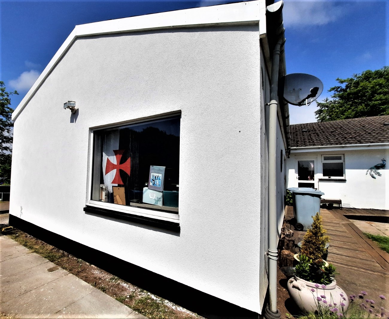 roughcast repair on bright white wall with large window