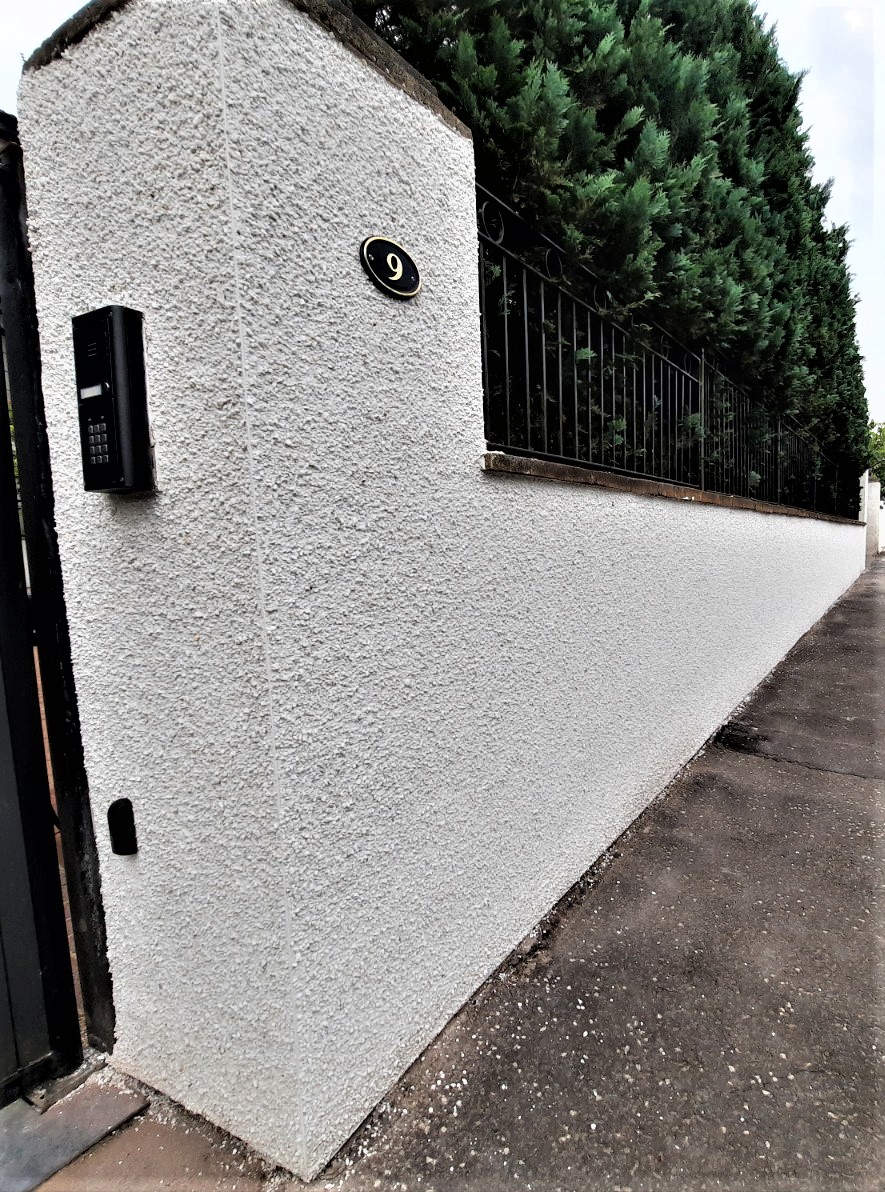 roughcaster Edinburgh applying fresh coat to long boundary wall