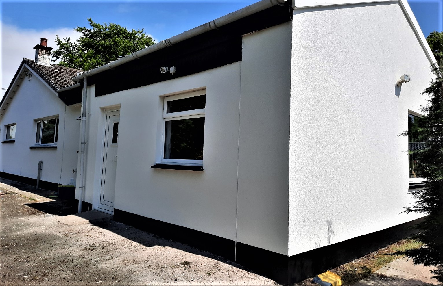 roughcast render repair on white façade with entrance door