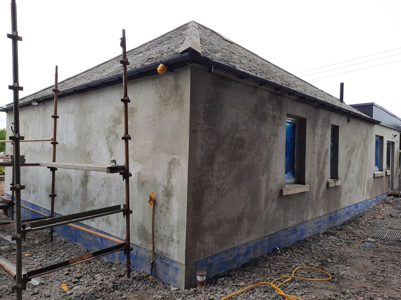 roughcast render repair in progress on gable end wall