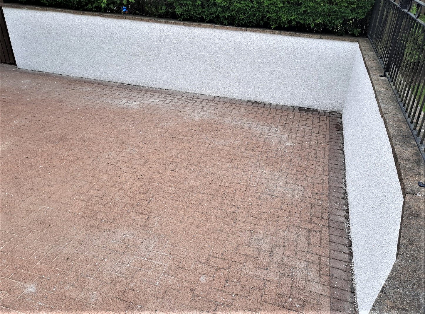 roughcast repair on smooth white courtyard wall