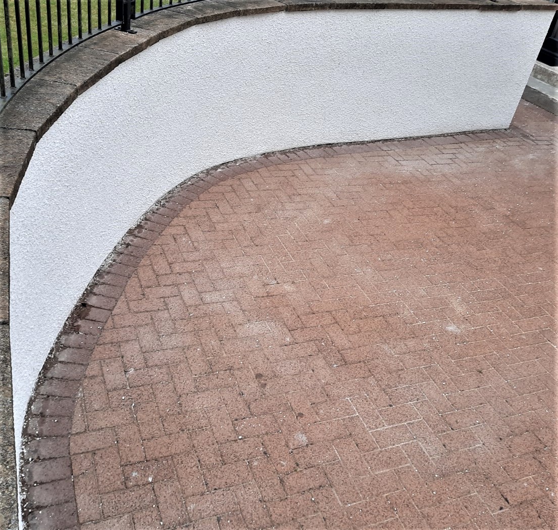 roughcast render repair along curved garden boundary