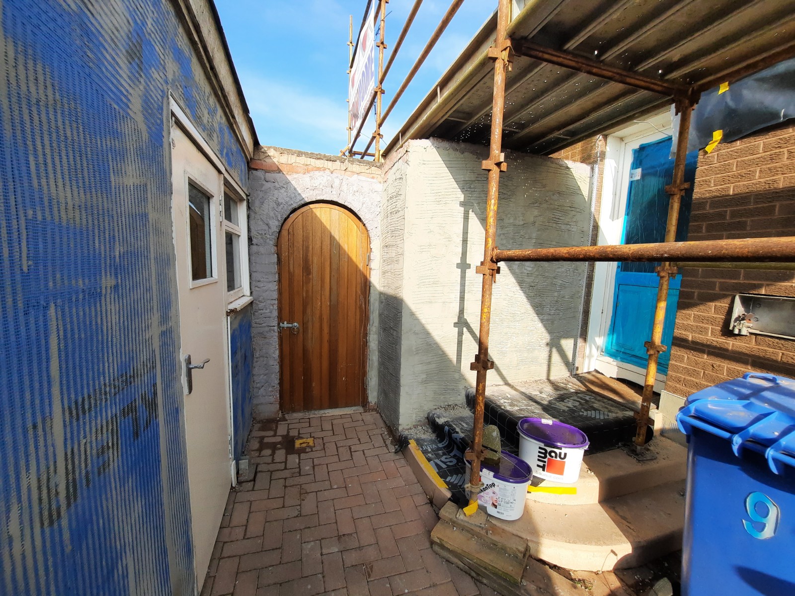 Rendering Edinburgh around wooden arched doorway under renovation
