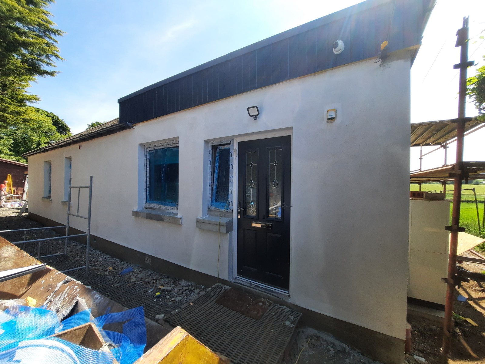 roughcast render Edinburgh applied to wall with blue-protected windows