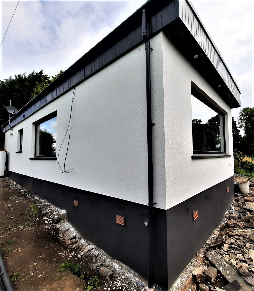 roughcast repair on white wall with dark lower section