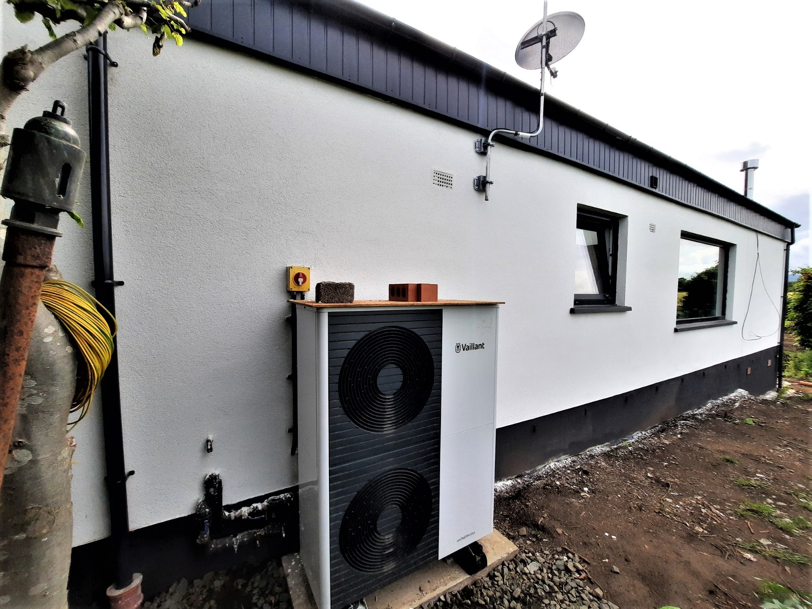 roughcast render repair beside outdoor heat pump unit