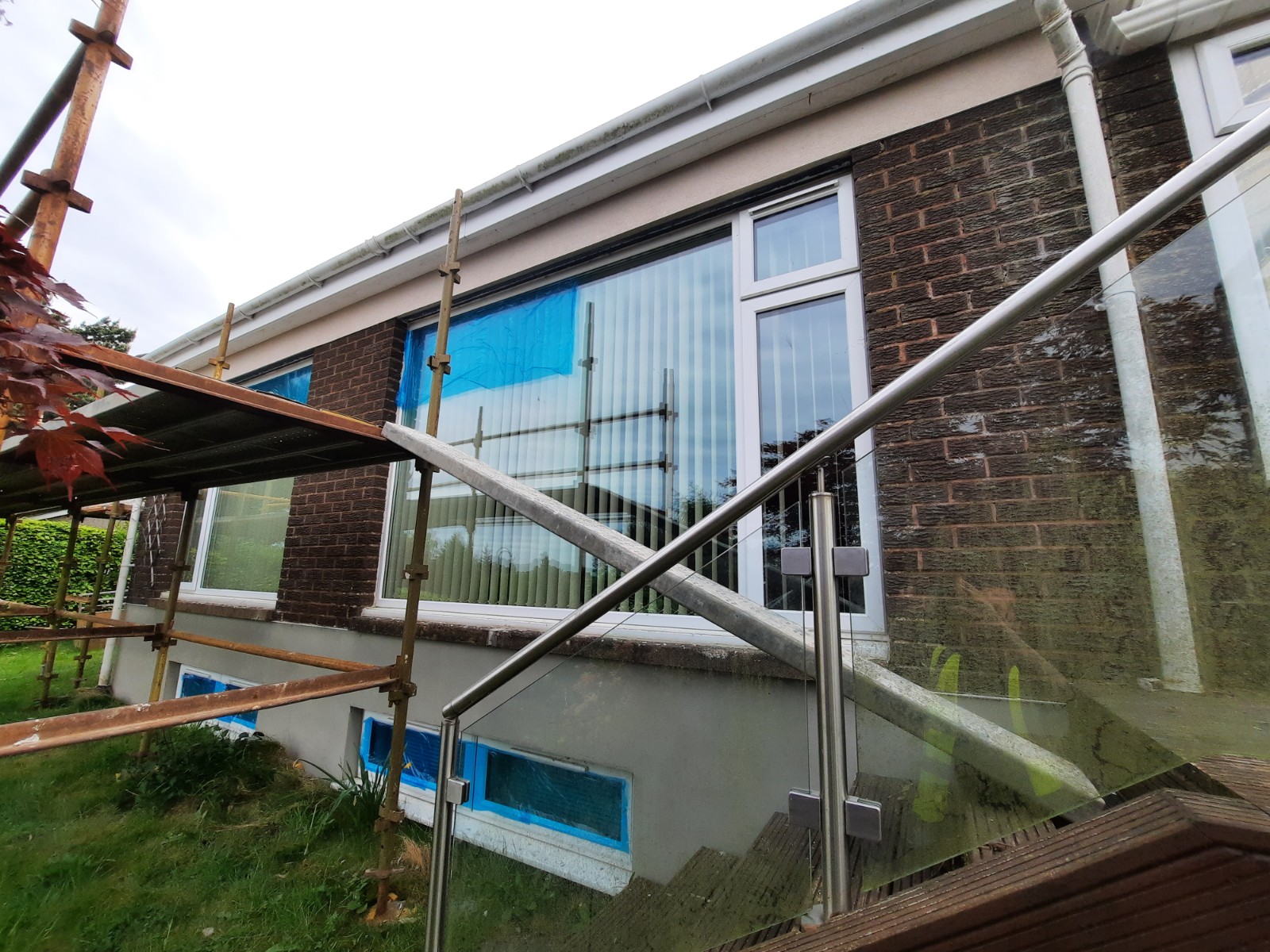 roughcasting Edinburgh on wall beneath white-framed conservatory windows