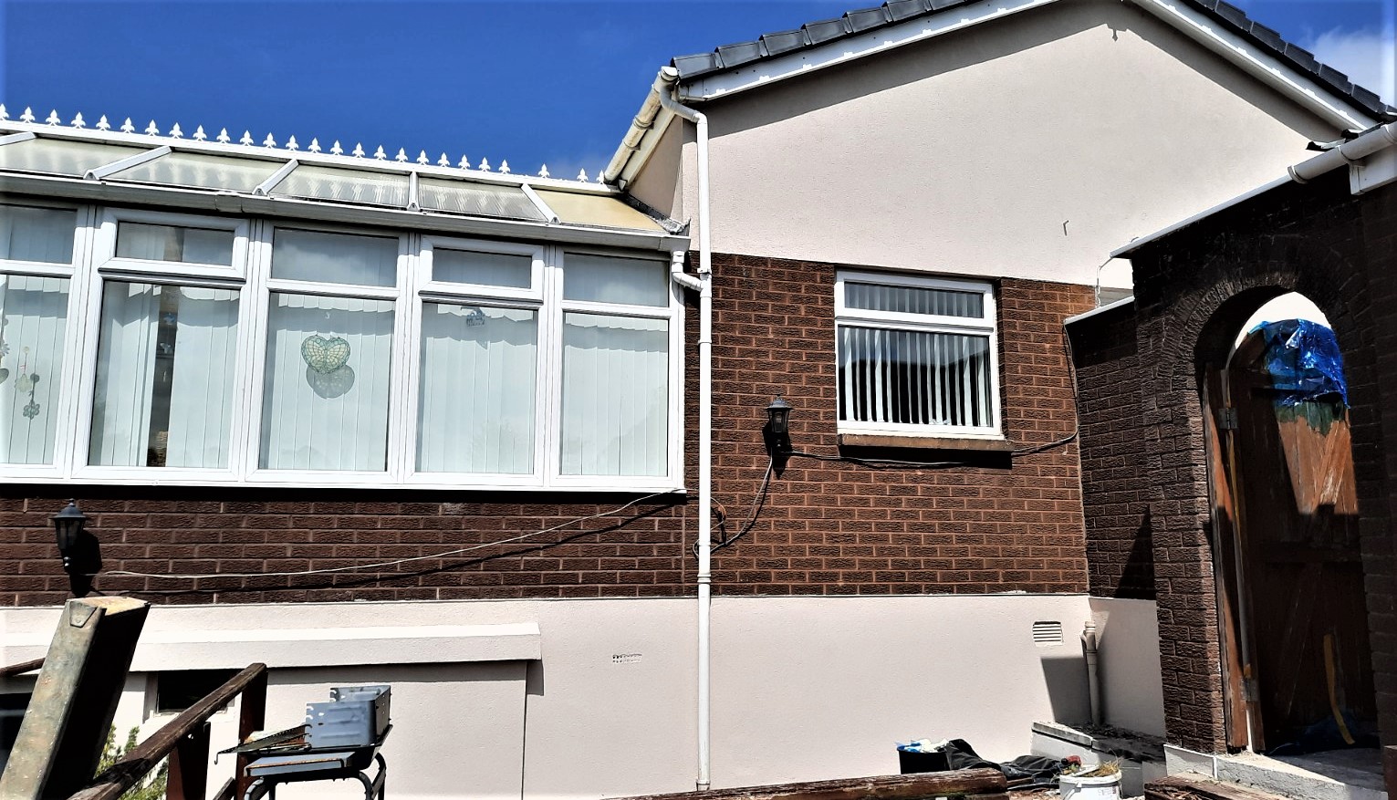 roughcast repair on wall with vertical drainage pipe