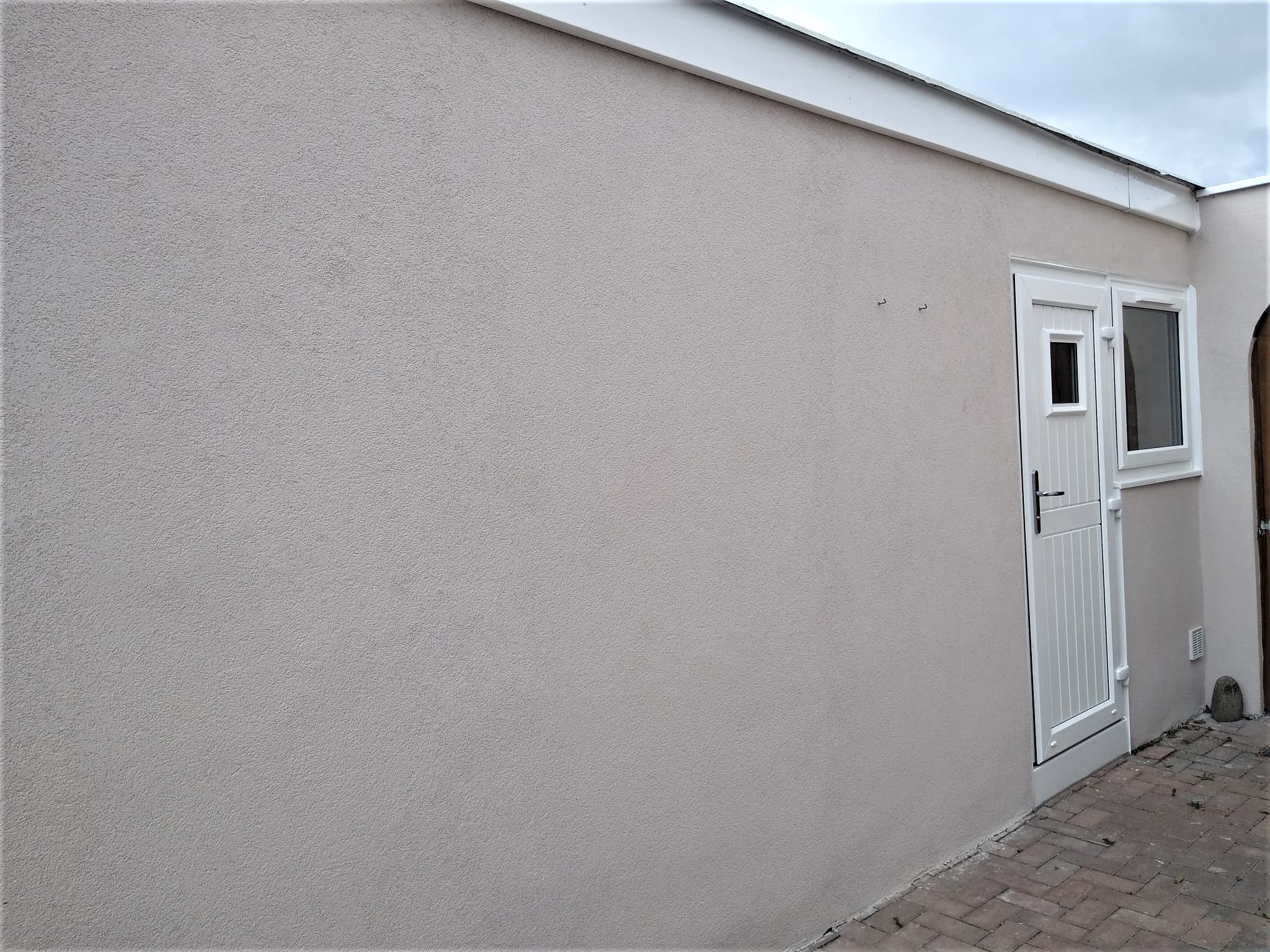 roughcast render repair on smooth gable end wall