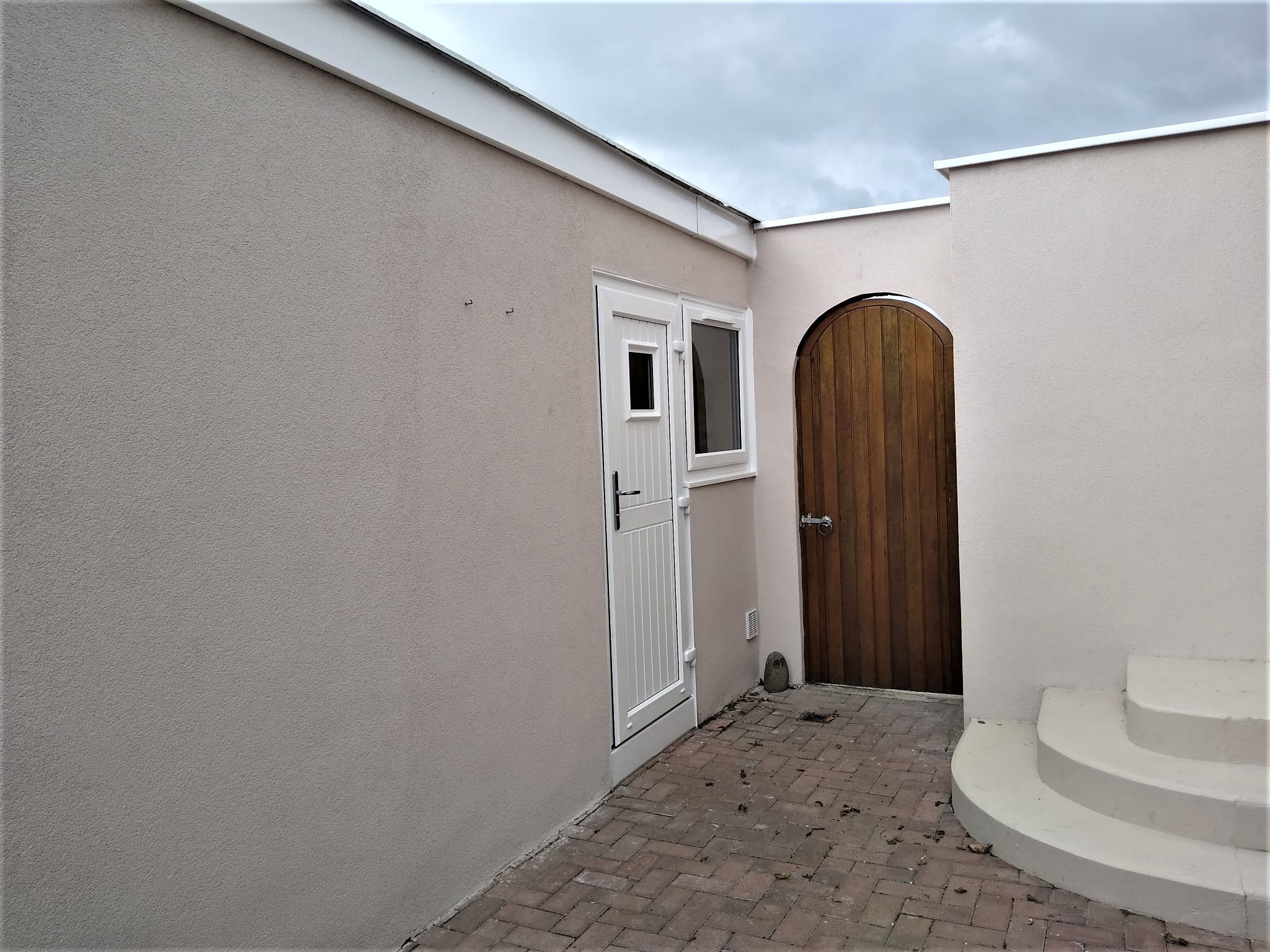 Rendering Edinburgh on front courtyard wall beside doorway