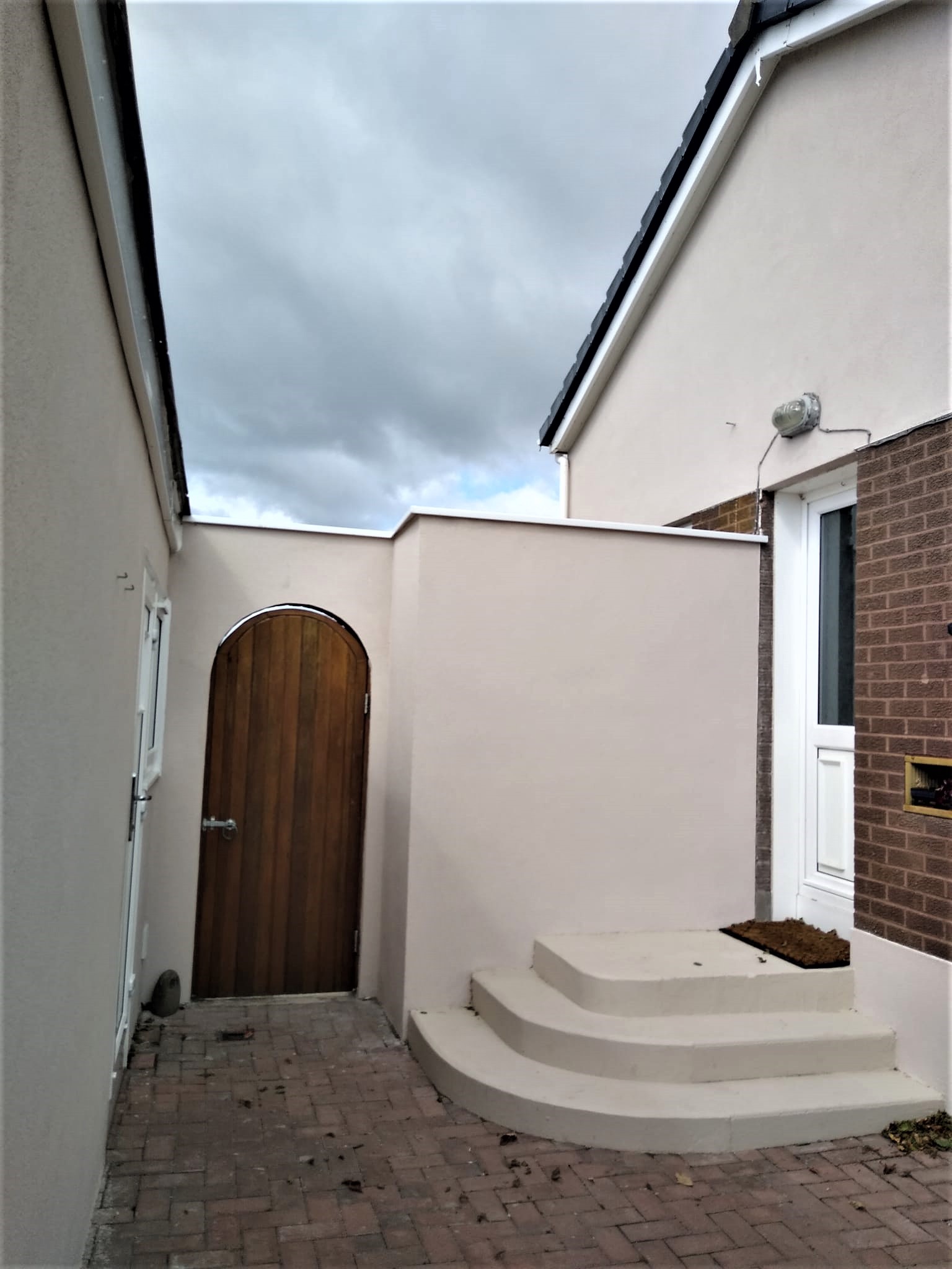 roughcast repair at arched entrance with smooth render