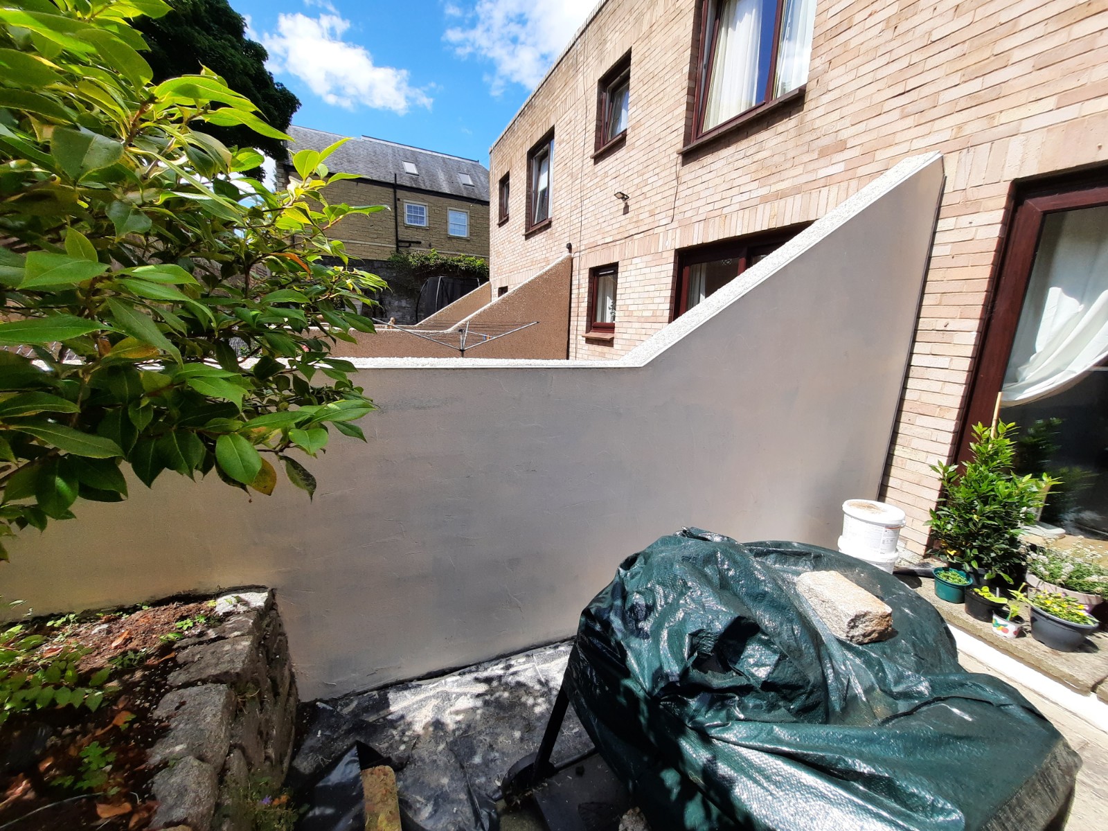 Rendering Edinburgh on tall boundary wall beside plants