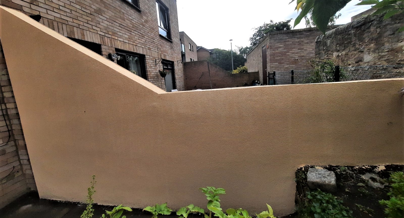 roughcast render repair on side garden wall