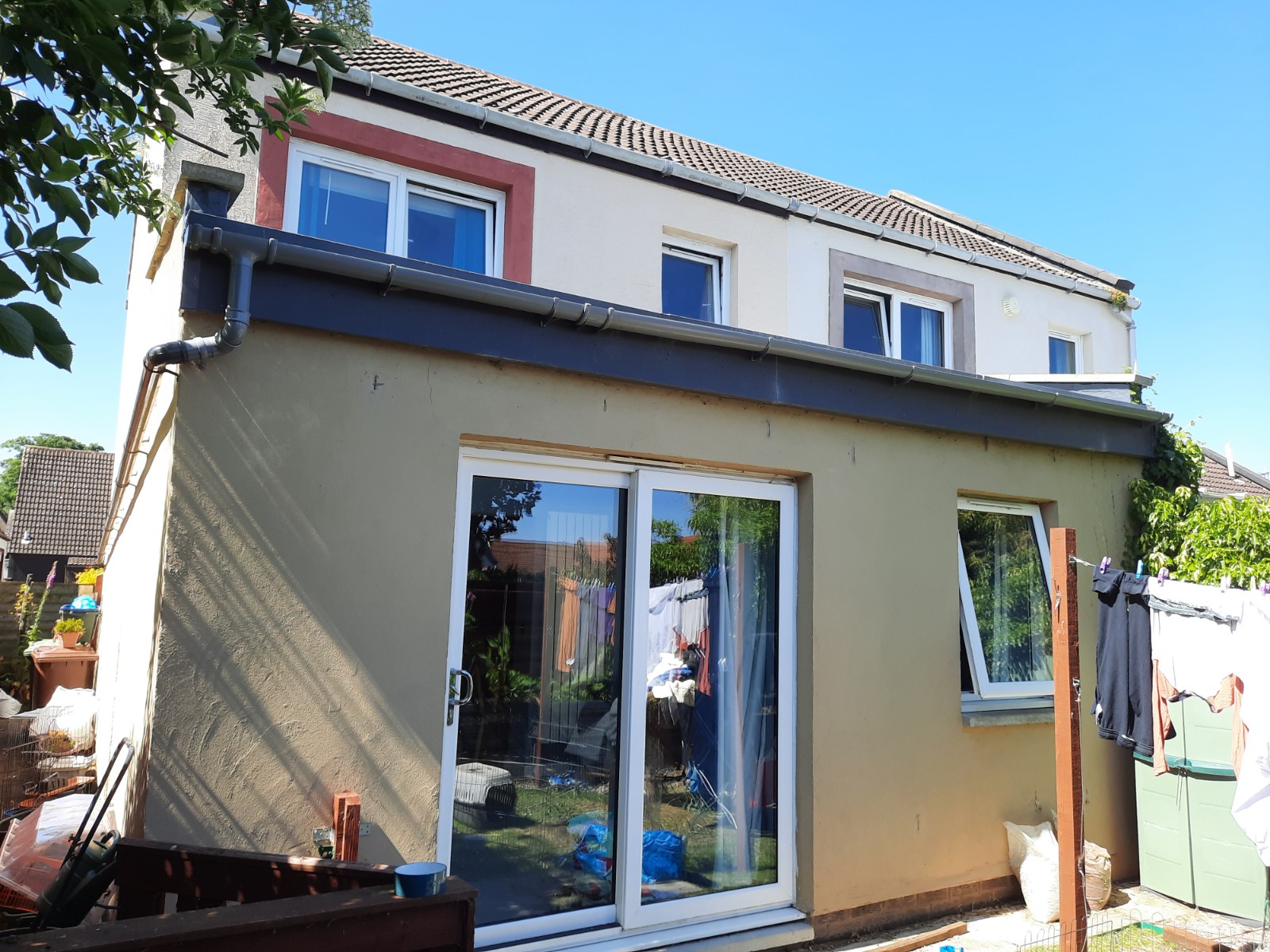 roughcast render repair on single-storey extension with sliding doors